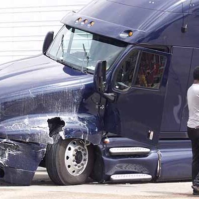 A man makes a call on his cell phone after his tractor trailer jackknifed during a collision with an SUV on I-35 in Texas.